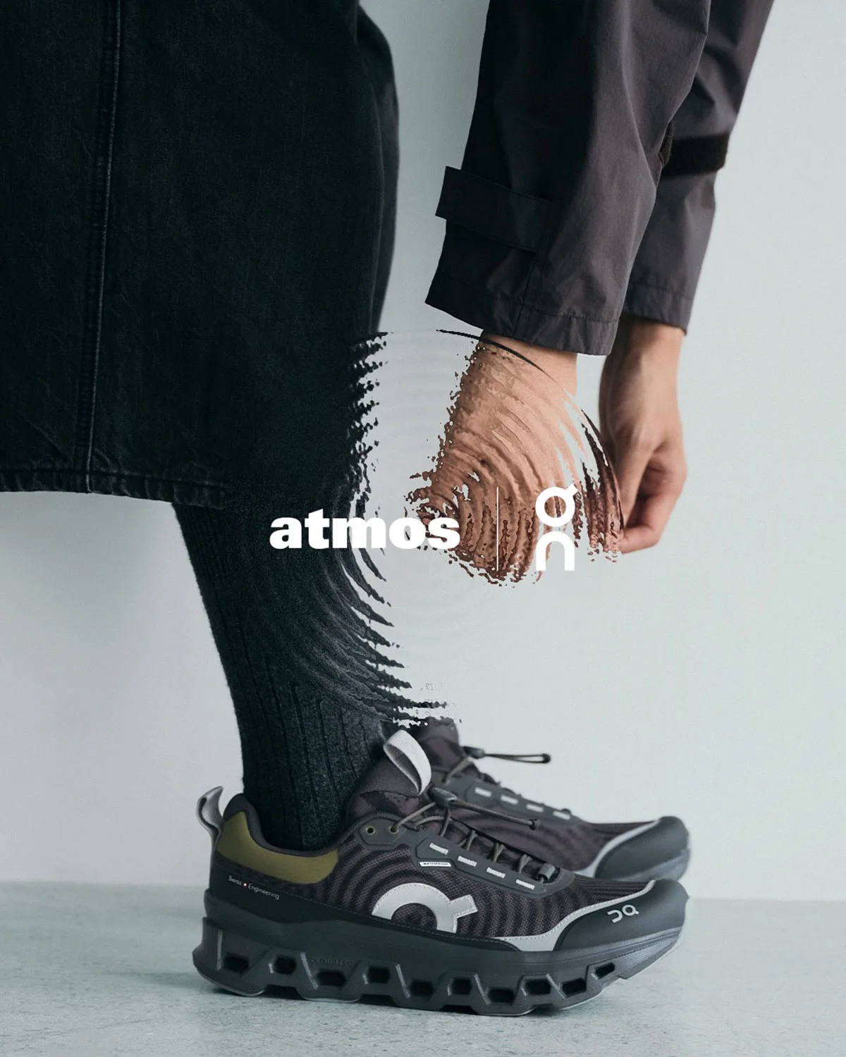 On-foot detail with black socks, olive heel tab and atmos and On logos overlaid, WP x atmos