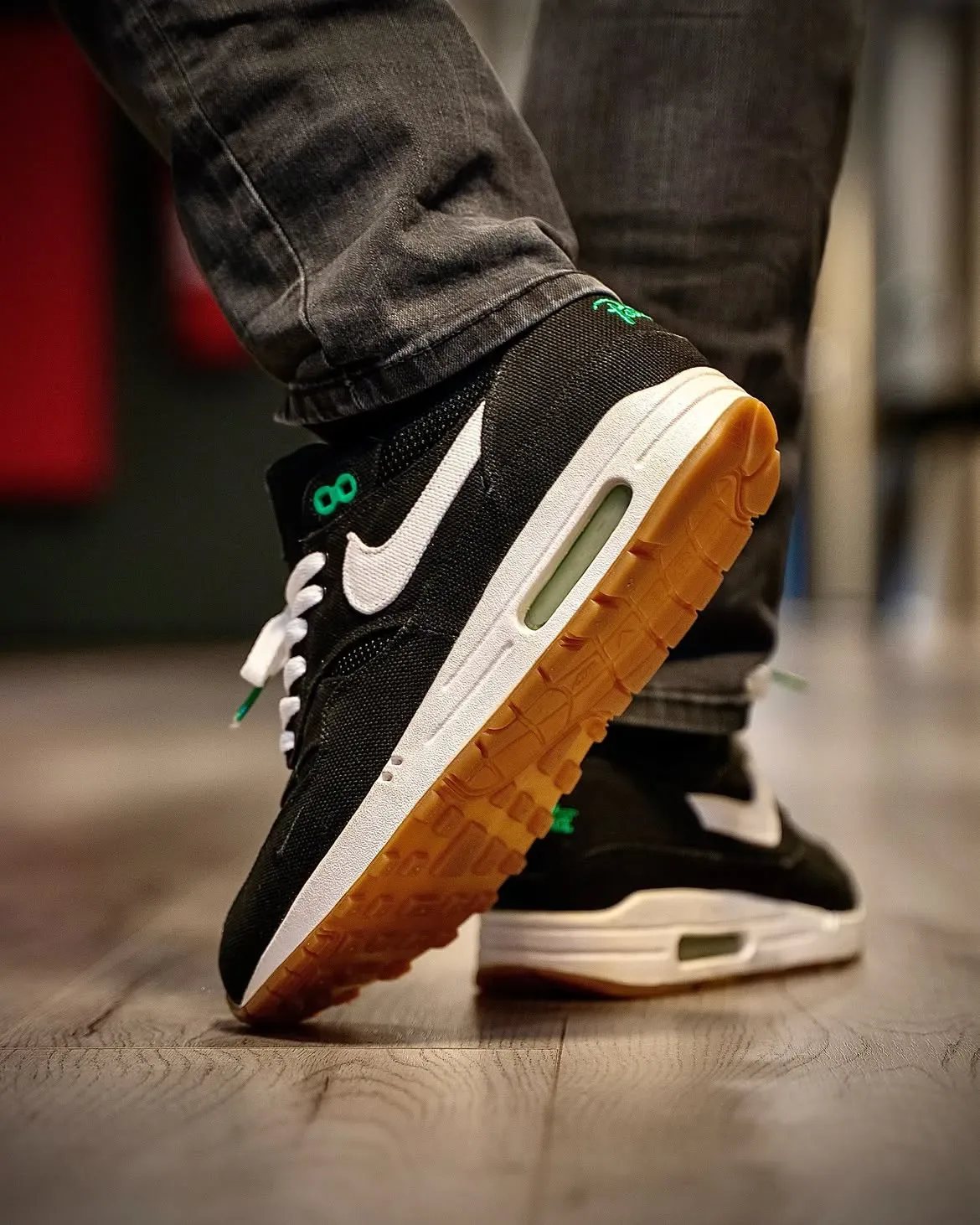 on-foot heel view of both shoes mid-stride, gum tread outsole, pale green Air window, Lucky Green