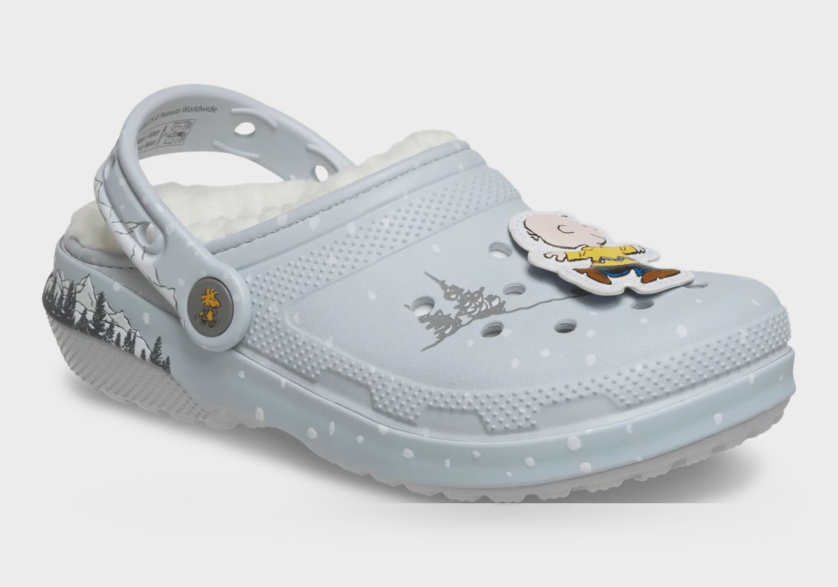 Three-quarter view of grey clog with fleece, snow dots, charm of boy in yellow shirt on toe, Classic Lined Clog