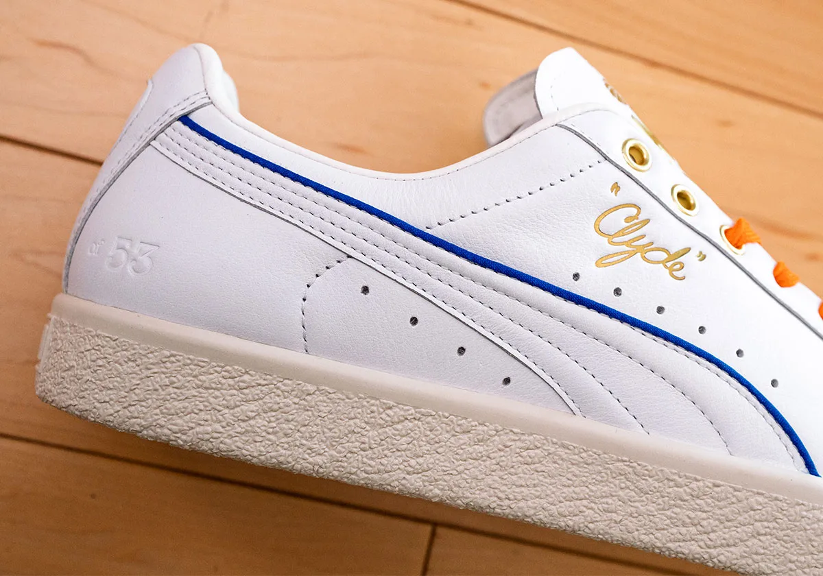 Close-up of white sneaker side with blue stripe, gold "Clyde" script, embossed "of 53" and cream sole, Ceremony