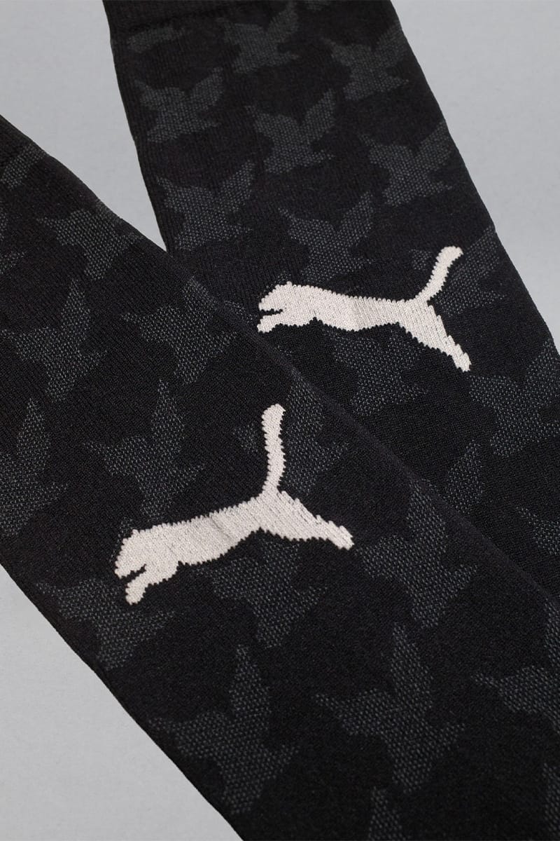 Detail of black socks with grey bird pattern and cream cat logos, IVORYxBLACK