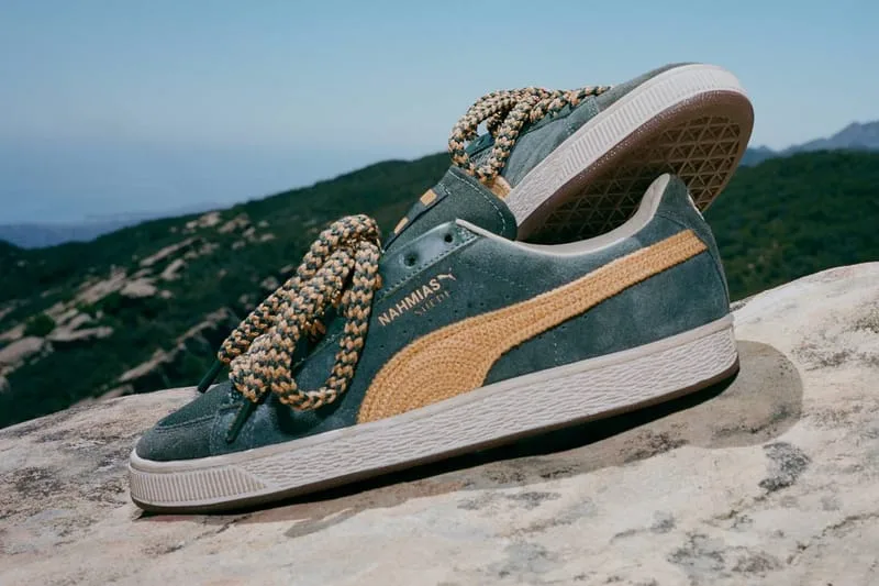 Lateral view of a green suede pair with tan crochet stripe and tan braided laces, hills behind, NAHMIAS Suede Crochet
