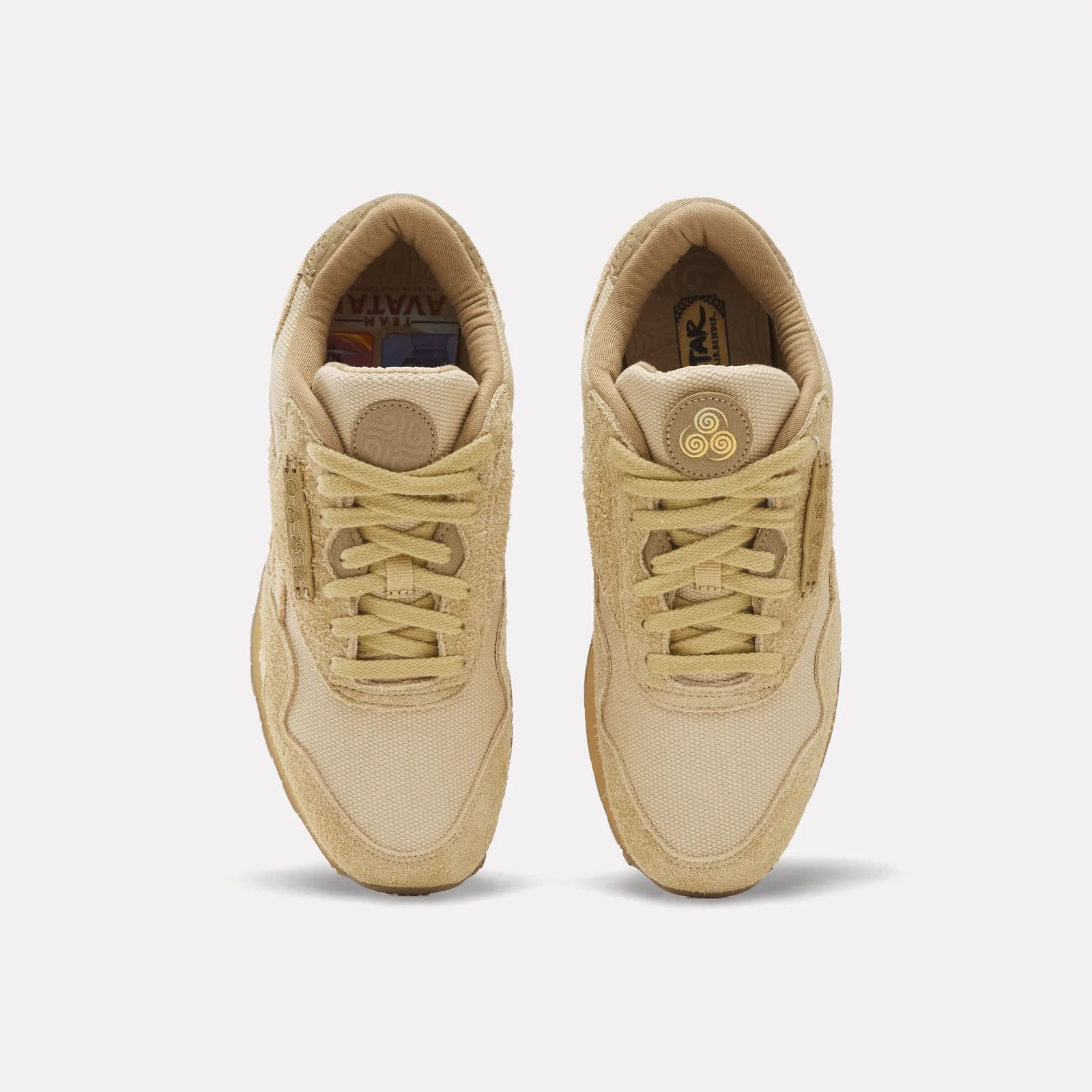 Top-down pair with tan laces, element lace plates and swirl badges on the tongues, Four Nations