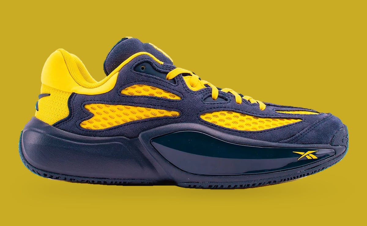 Lateral view on mustard backdrop, navy suede and yellow mesh panels, yellow Reebok logo, Brew Crew