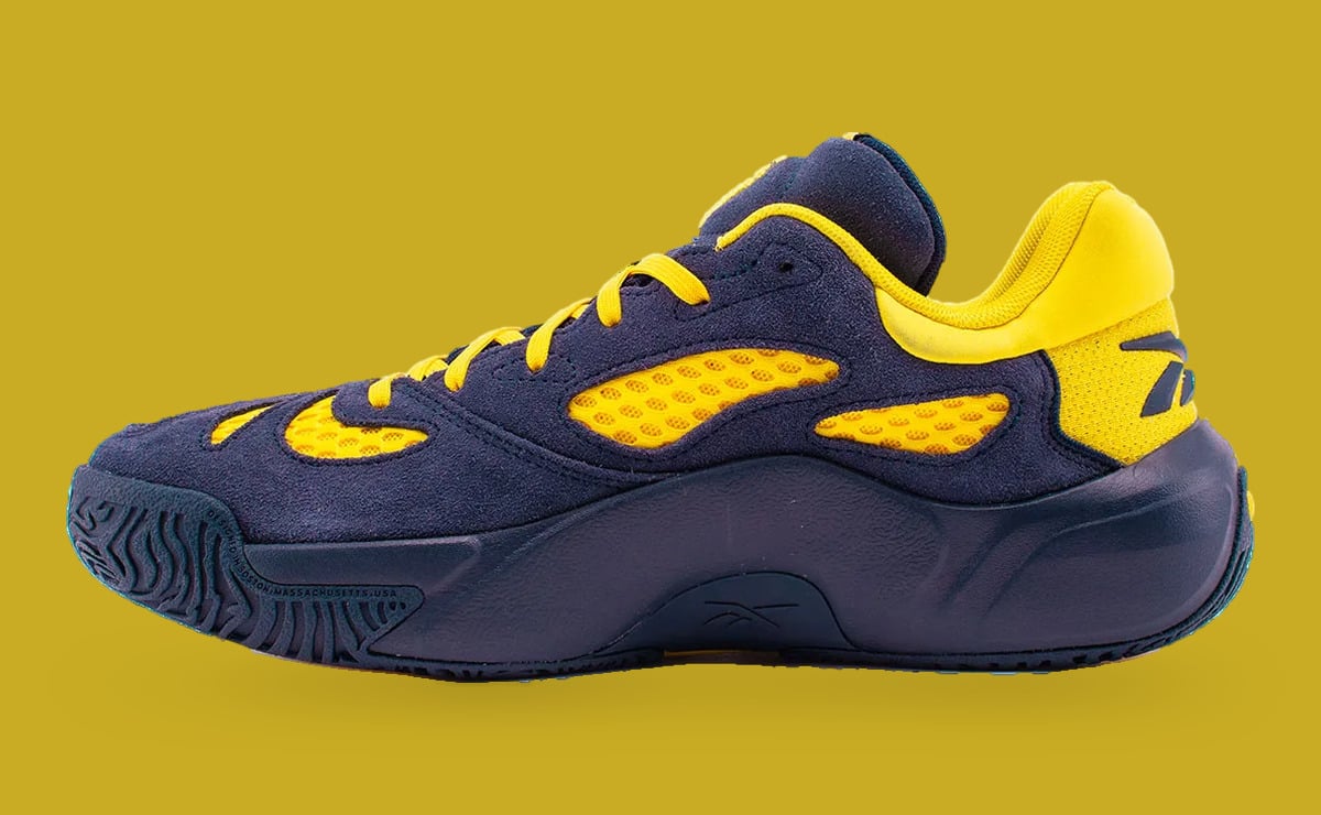 Medial view on mustard backdrop, navy suede upper, yellow mesh panels and yellow collar, Brew Crew