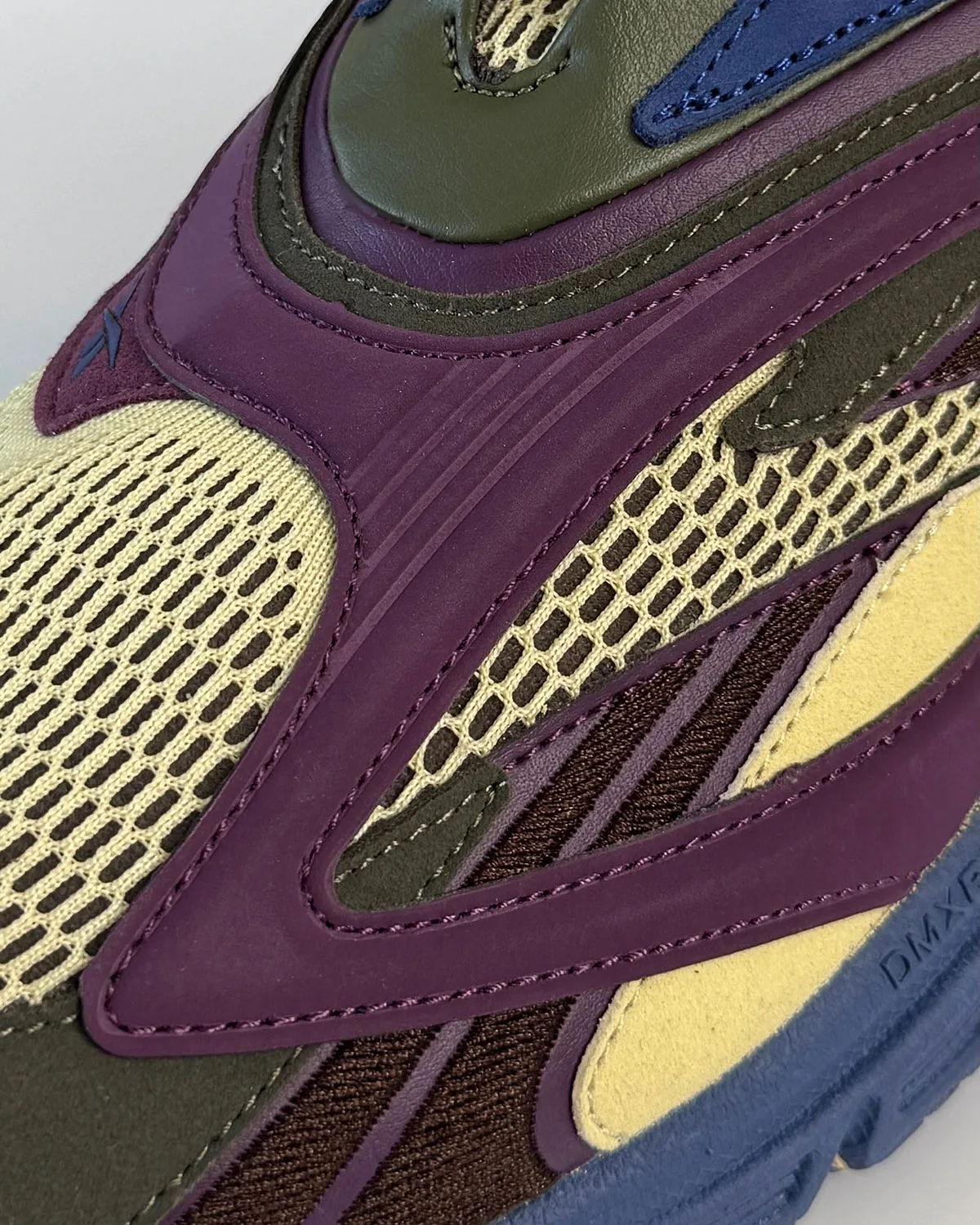 Close-up of purple overlays over cream and brown mesh, blue sole with DMX lettering, Purple Suede