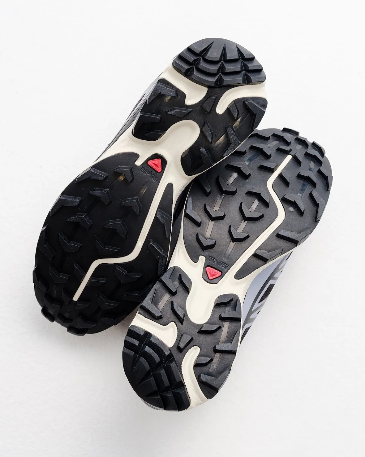 Outsole pair, black lugs, cream midsole, red triangle logo, white backdrop, 5 AM