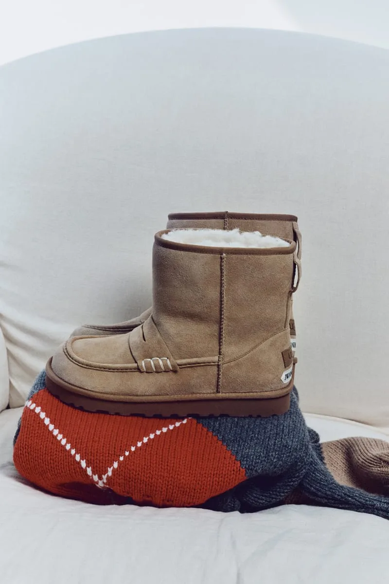 Lateral view of tan suede loafer boots stacked on a red, grey and white argyle knit, with a JW Anderson label at the heel, x