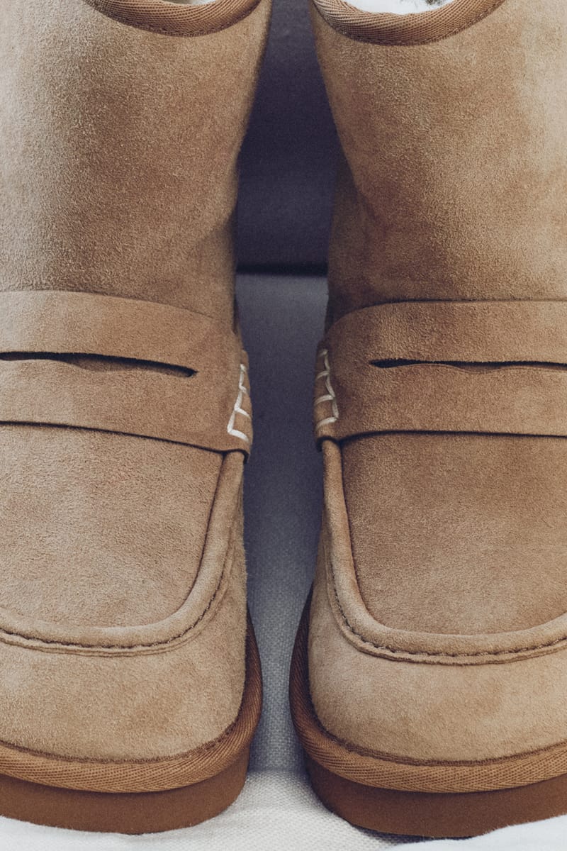 Close-up toe view of two tan suede loafer boots side by side, with penny straps and white stitching, x JW Anderson