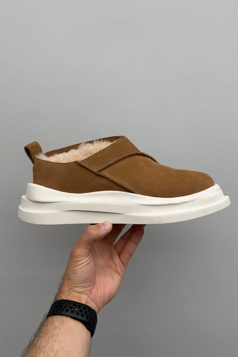 In-hand lateral view of tan suede slip-on with fleece lining and stacked white platform sole, Heritage Utility Grizz