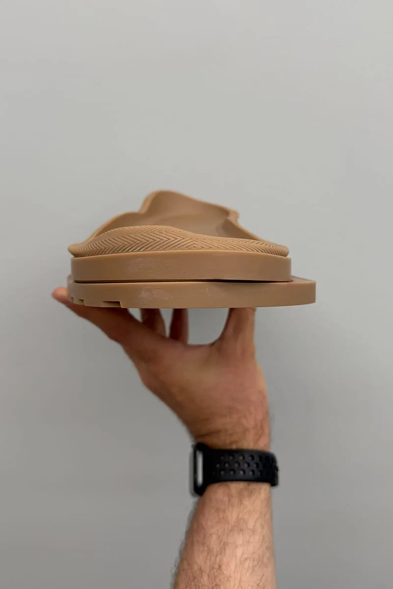 In-hand side view of a tan sole unit with herringbone texture and no upper attached, Heritage Utility Grizz