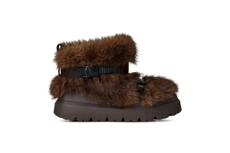 Lateral view of brown faux-fur boot with black buckle strap and chunky dark brown lugged sole, Heritage Utility Grizz