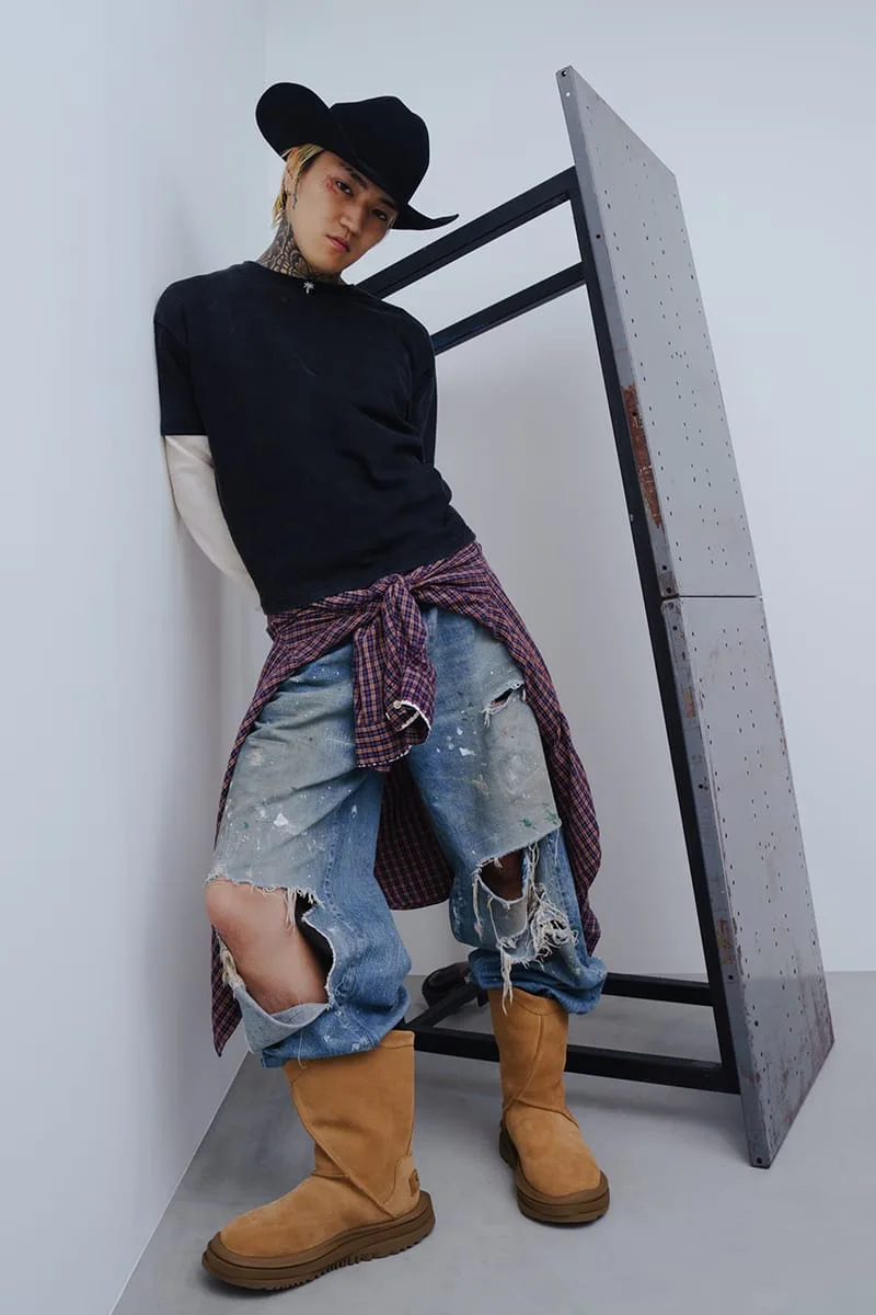 On-foot shot of model in black cowboy hat, ripped jeans and tan suede boots beside a metal panel, Heritage Utility Grizz