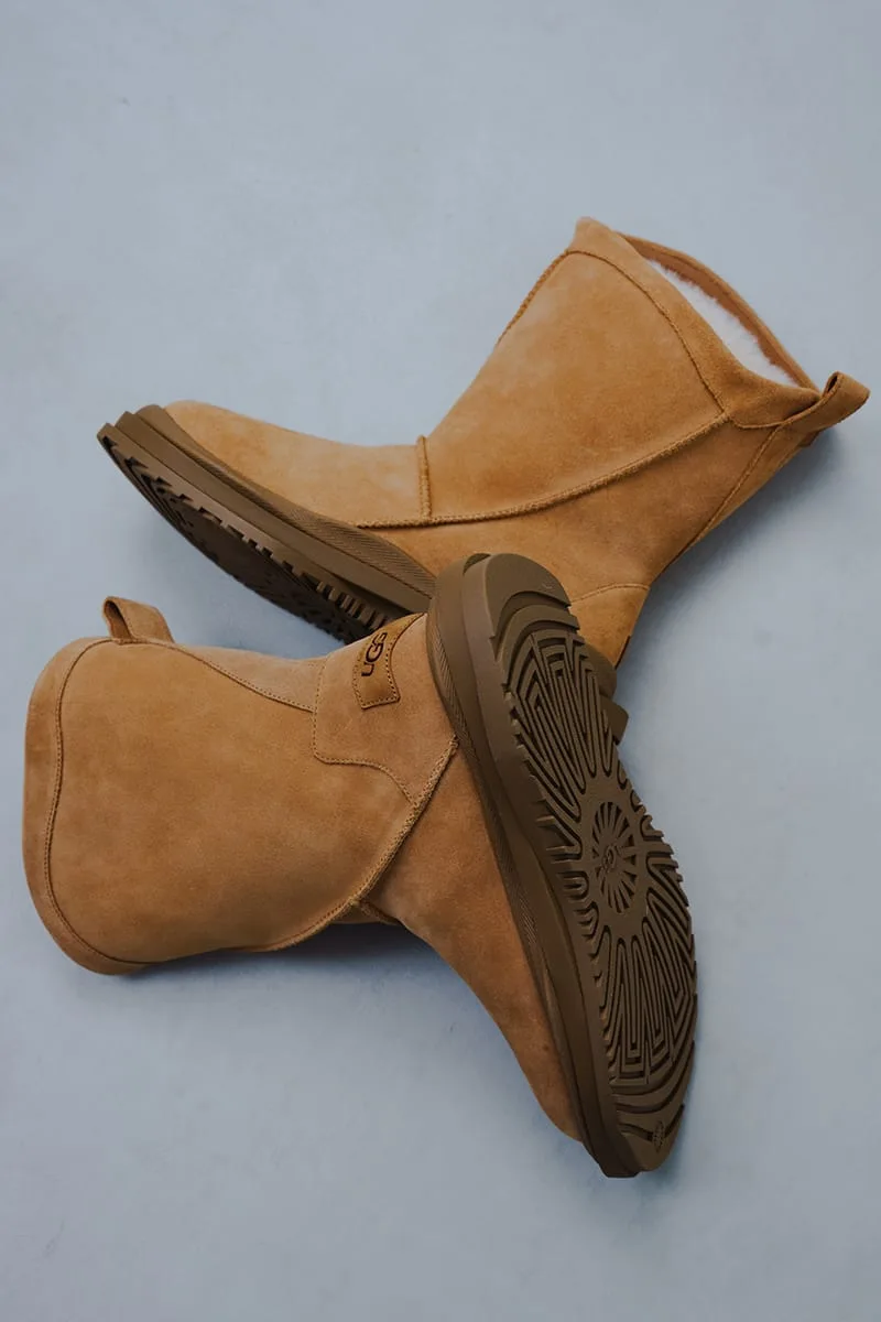 Top-down pair of tan suede boots, one showing a patterned brown outsole and UGG heel tab, Heritage Utility Grizz