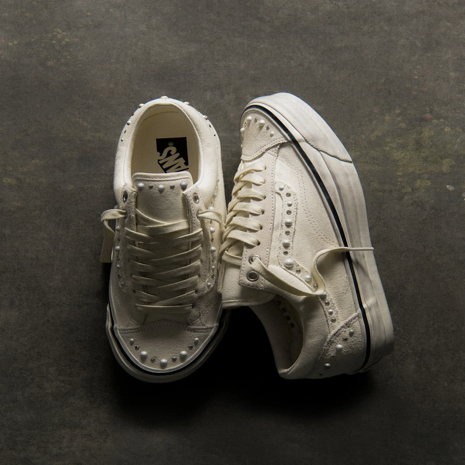 pair laid on dark mottled surface, soles and pearl-studded toes facing each other, Marshmallow