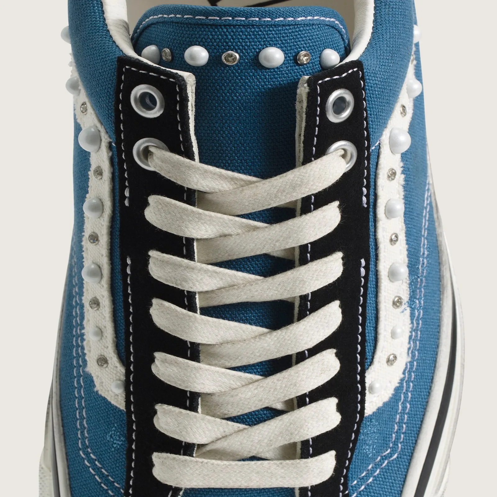 close-up of laces and eyelets with pearl studding along tongue edge, Navy Blue