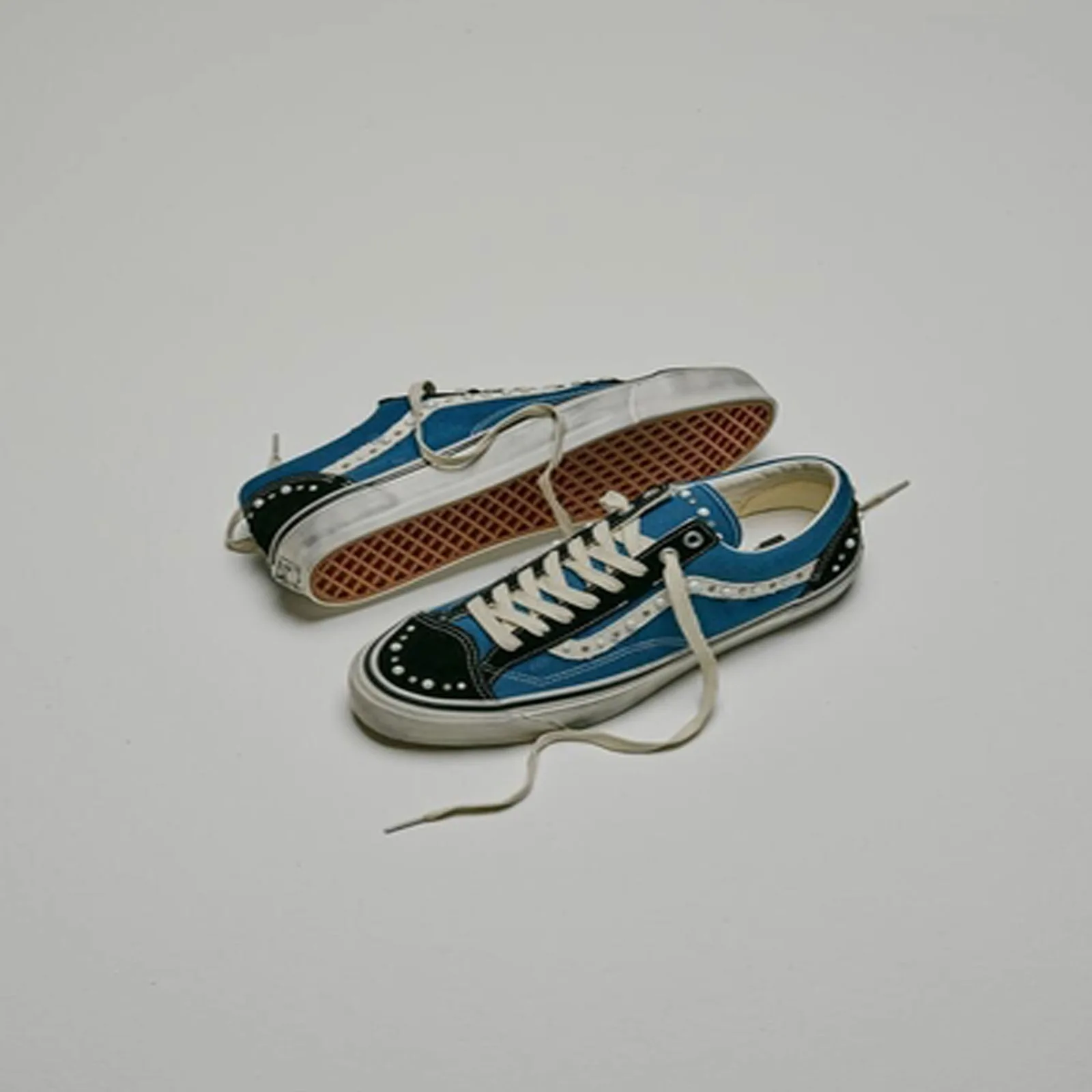 pair soles up, showing gum herringbone tread and black heel studs, Navy Blue