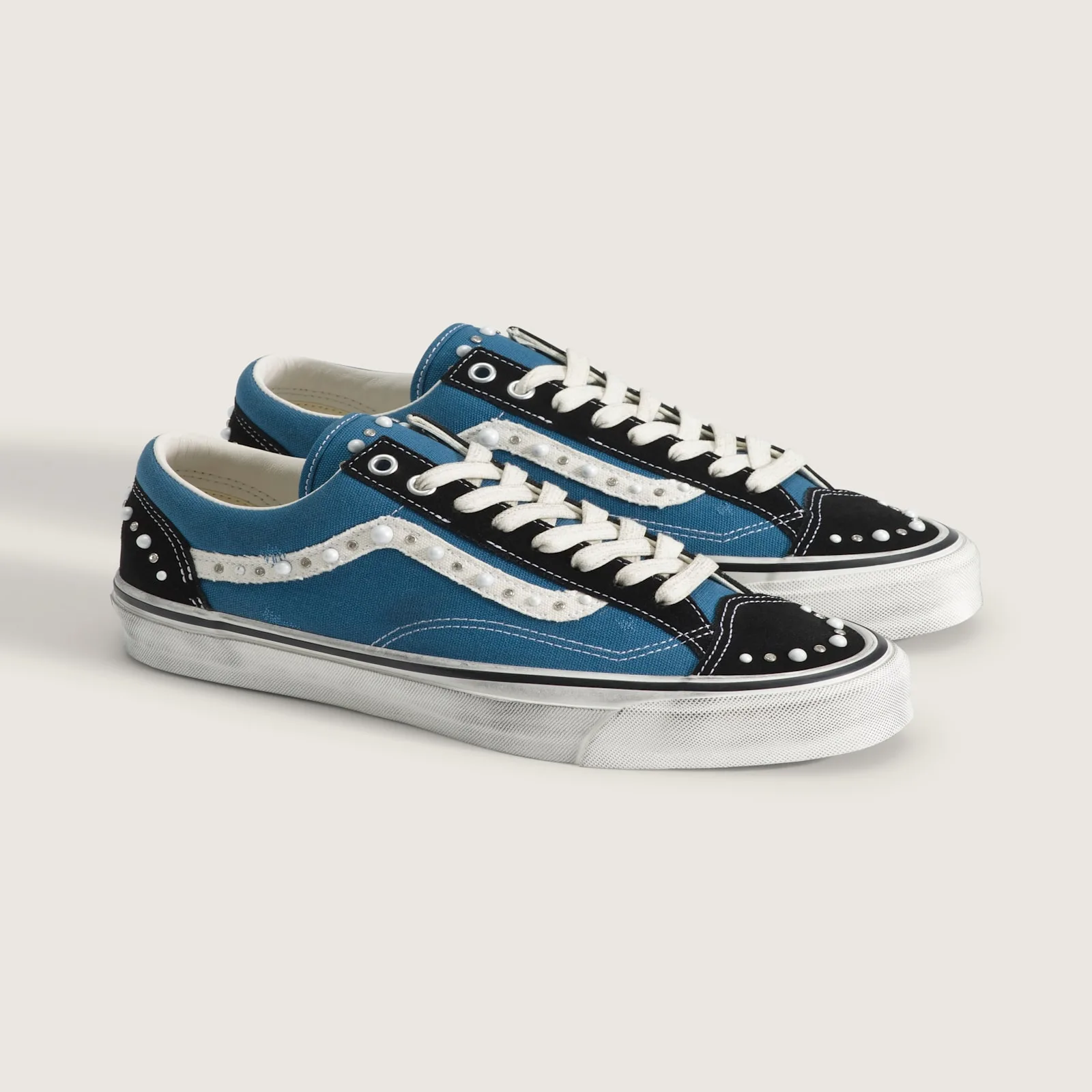 pair at angle showing toe box studding and worn white soles, Navy Blue