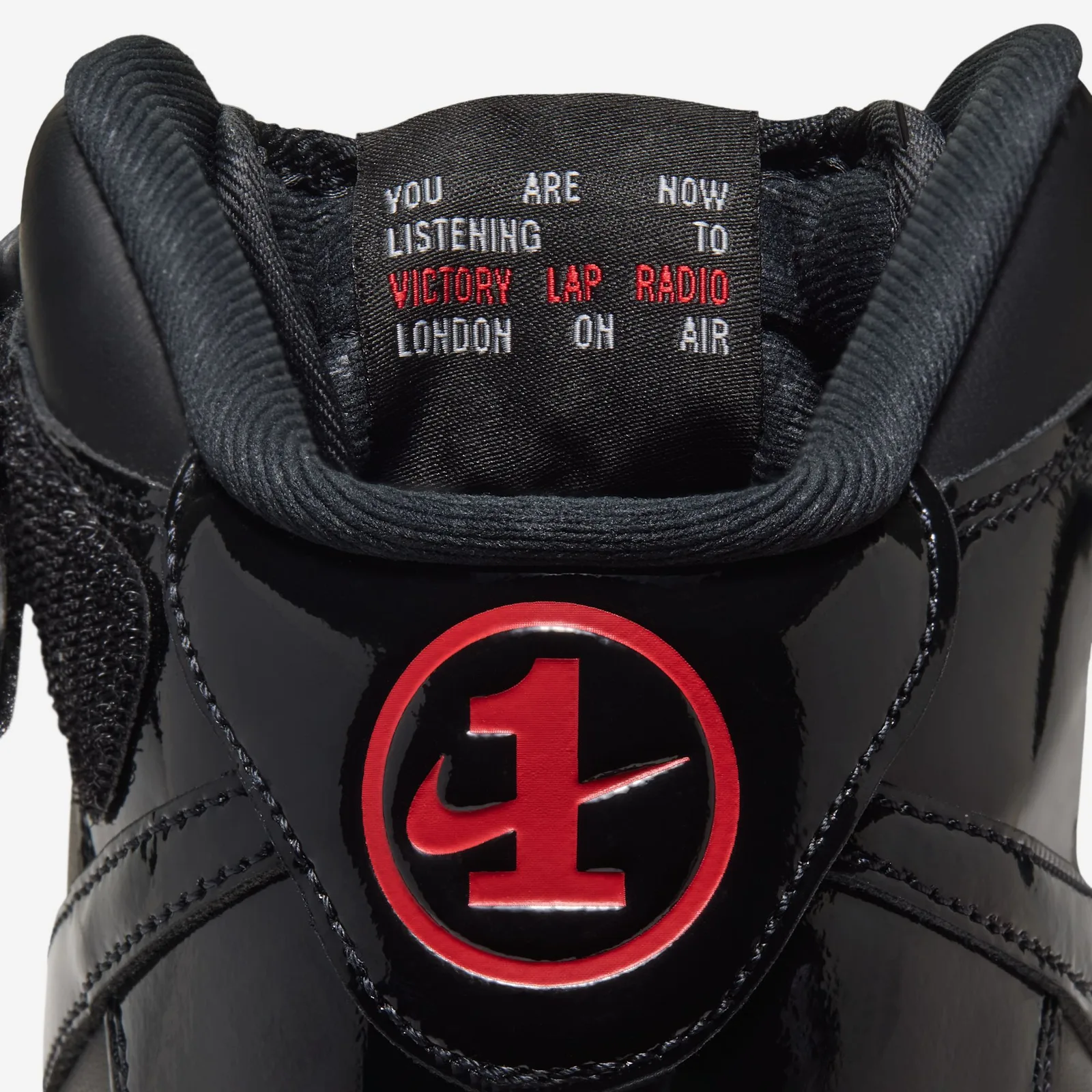 Detail of tongue label reading 'You are now listening to Victory Lap Radio London on air' above a red 1 badge, Black Patent