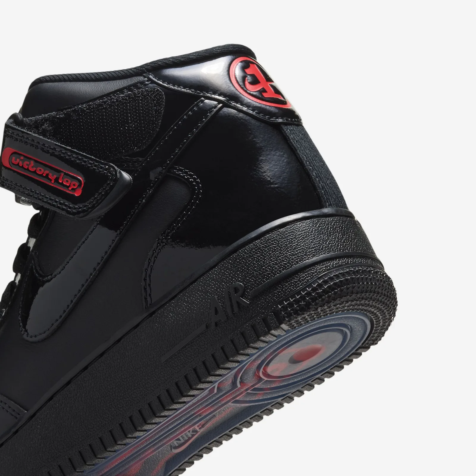Detail of heel and outsole, red Victory Lap strap tag, red heel badge, translucent red-blue sole, Black Patent