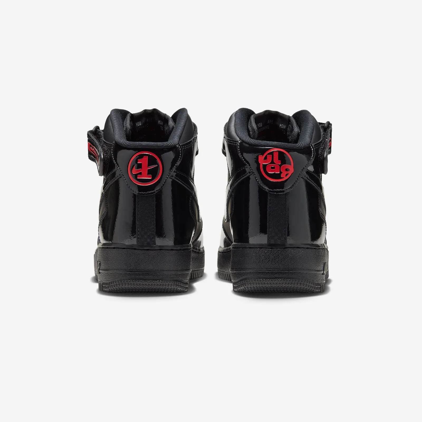 Heel view of pair, red circular badges with a 1 and Nike swoosh on black patent, Black Patent